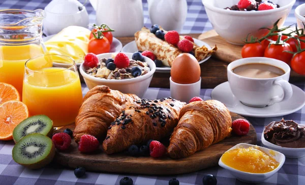 Café da manhã servido com café, suco, croissants e frutas — Fotografia de Stock