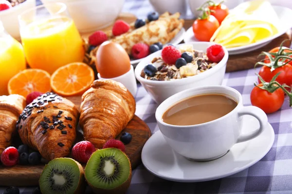 Café da manhã servido com café, suco, croissants e frutas — Fotografia de Stock