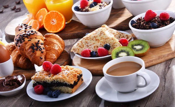 Breakfast served with coffee, juice, croissants and fruits Stock Photo