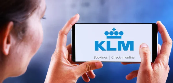 Vrouw met smartphone met logo van KLM Airlines — Stockfoto