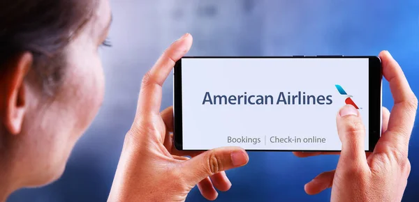 Žena držící smartphone s logem American Airlines — Stock fotografie