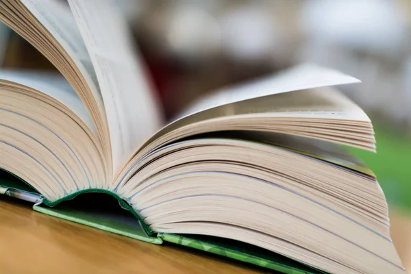 Livro aberto deitado sobre a mesa na biblioteca — Fotografia de Stock