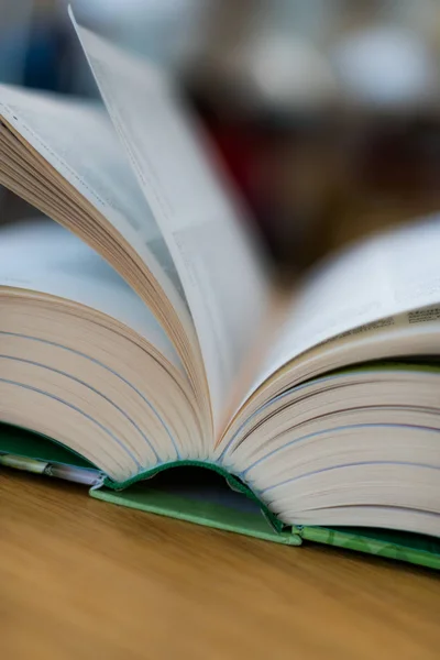 Livro aberto deitado sobre a mesa na biblioteca — Fotografia de Stock