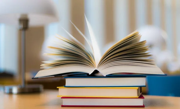 Open book lying on the table in the library — Stock Photo, Image