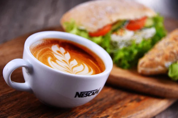 Cup of Nescafe coffee and sandwiches — 스톡 사진