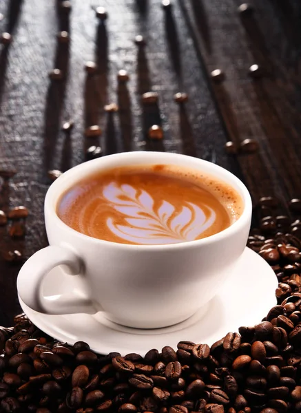 Composição com xícara de café café com leite e grãos de café — Fotografia de Stock