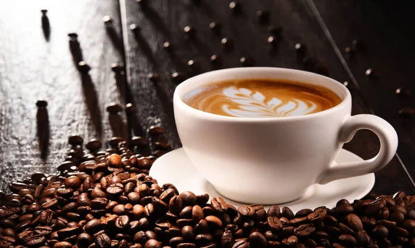 Composição com xícara de café café com leite e grãos de café — Fotografia de Stock