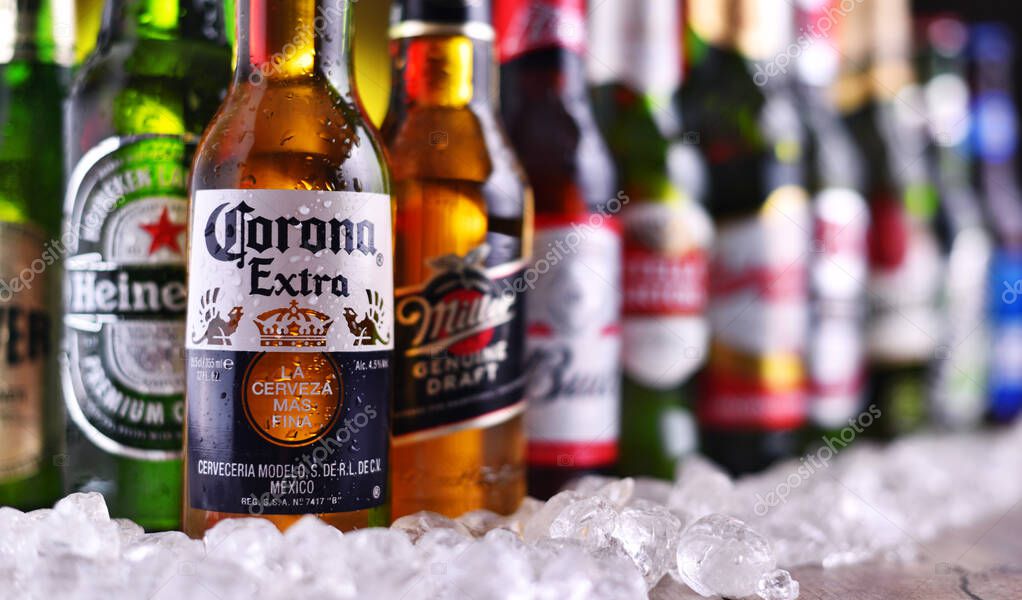 POZNAN, POL - DEC 23, 2019: Bottles of famous global beer brands including Heineken, Becks, Bud, Miller, Corona, Stella Artois, and Pilsner Urquell