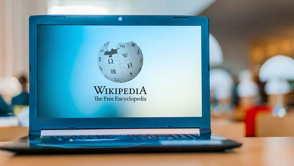 Ordenador portátil que muestra el logo Wikipedia — Foto de Stock