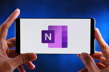 POZNAN, POL - 19 Şubat 2020: Microsoft tarafından geliştirilen Office aile yazılımı ve hizmetlerinin bir parçası olan Microsoft OneNote programının logosunu gösteren akıllı telefonları tutan eller