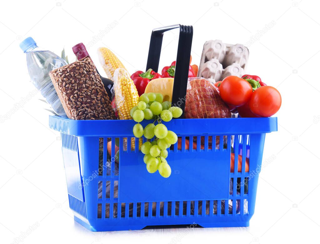 Plastic shopping basket with assorted grocery products isolated on white