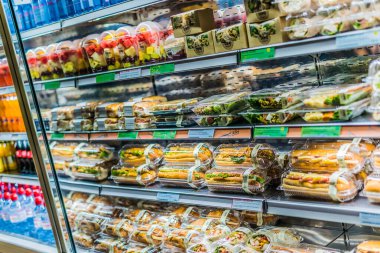 Doha, Katar - 28 Şubat 2020: Ticari buzdolabında sergilenen önceden paketlenmiş sandviç, salata ve içecekler