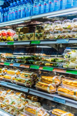 Doha, Katar - 28 Şubat 2020: Ticari buzdolabında sergilenen önceden paketlenmiş sandviç, salata ve içecekler