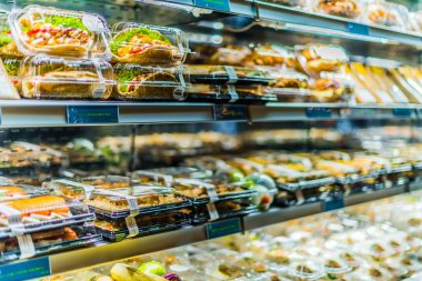 Doha, Katar - 28 Şubat 2020: Ticari buzdolabında sergilenen önceden paketlenmiş sandviç, salata ve içecekler
