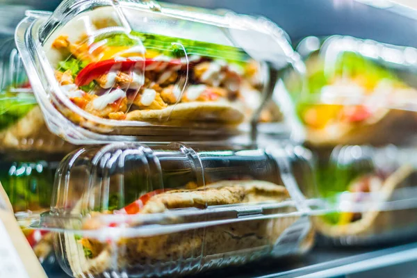 Chilli chicken with pita, pre-packaged sandwiches displayed in a commercial refrigerator