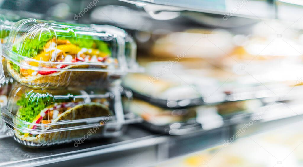 Chilli chicken with pita, pre-packaged sandwiches displayed in a commercial refrigerator