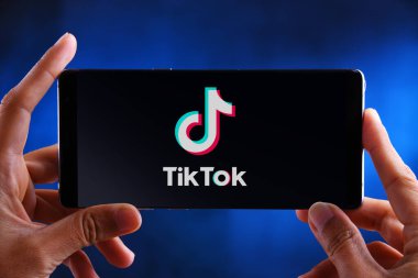 POZNAN, POL - 19 Şubat 2020: ByteDance 'e ait bir Çin video paylaşım sosyal ağ servisi olan TikTok' un akıllı telefon logosunu gösteren eller