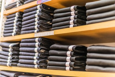 Giysi ürünleri bir giyim mağazasının rafında..