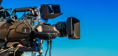 Sokaktaki sosyal etkinliği kaydeden tripoddaki profesyonel televizyon kamerası.