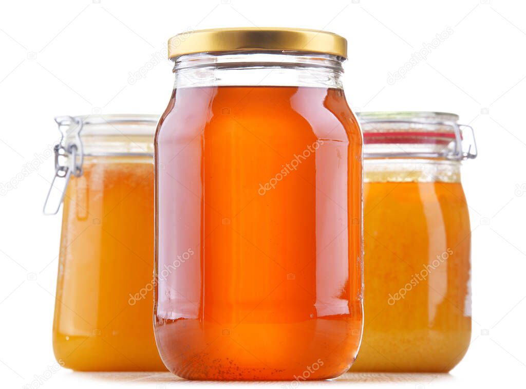 Composition with large jars of honey isolated on white