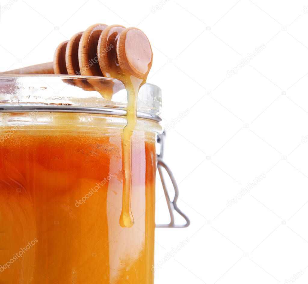 Composition with stick and open jar of honey.