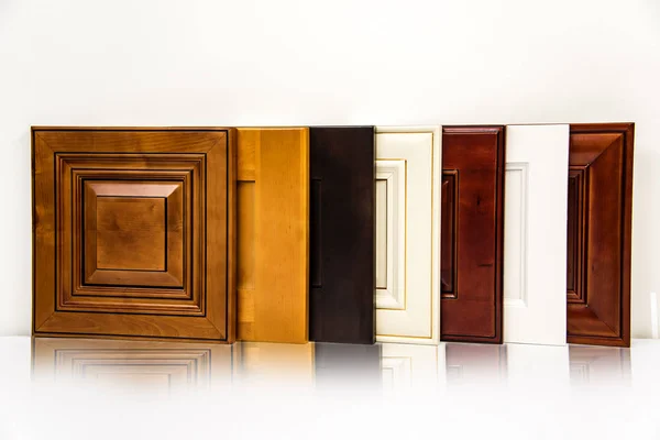 Porta de armários de cozinha de madeira de luxo alinhada na superfície do balcão da cozinha com fundo branco — Fotografia de Stock