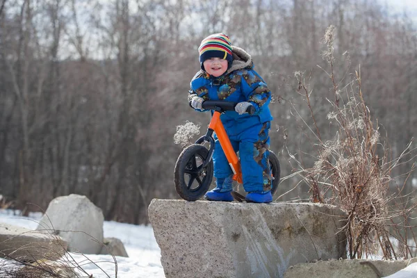 Child in ride balance bike (run bike) at winter