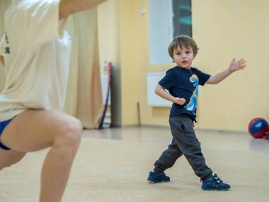 Çocuk eğitim kung fu (wushu) için. Trenler döver ve tekrarlar koç için yapmak. Isınma üzerinde atletik erkek.