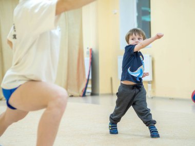Sevimli küçük çocuk dövüş sanatları devreye girer. Bebek başladı ve hayali düşman yumruk atıyor. Genel kompleksleri egzersizleri Kung-Fu.