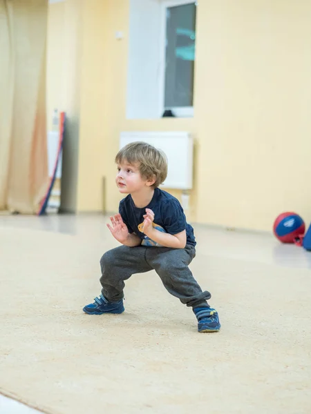 Deporte niño alegre haciendo un conjunto de ejercicios para estirar. Calentar antes de las clases de artes marciales (kung fu, wushu ). — Foto de Stock