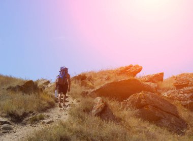 Yalnız bir adam büyük bir sırt çantası ile dağlar, yol yürür