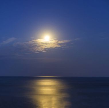 büyük parlak ay deniz ve ay ışığının aydınlattığı bir yol üzerinde. güzel manzara