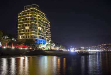 Sahilde güzel bina. gece manzarası, su görünür yansımalar