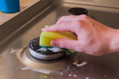 Deterjan köpük ve elektrik hob üzerinde sünger ile. Yağ ve pas yıkama için uygulanan elektrikli Ocak için