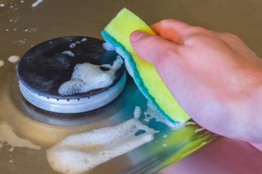 Deterjan köpük ve elektrik hob üzerinde sünger ile. Yağ ve pas yıkama için uygulanan elektrikli Ocak için