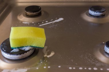 Deterjan köpük ve elektrik hob üzerinde sünger ile. Yağ ve pas yıkama için uygulanan elektrikli Ocak için
