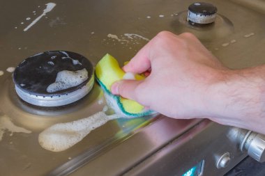 Deterjan köpük ve elektrik hob üzerinde sünger ile. Yağ ve pas yıkama için uygulanan elektrikli Ocak için