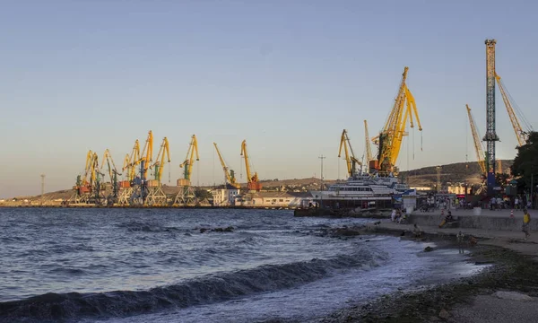 Port maritim mare la apusul soarelui, macarale văzute, mare și cer — Fotografie, imagine de stoc