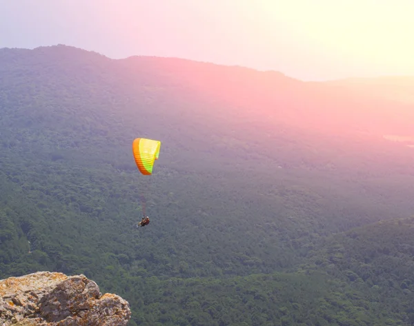 Deportista vuela parapente en el cielo. Parapente deporte peligroso — Foto de Stock