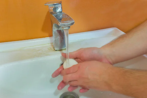 Uomo si lava le mani con acqua e sapone nella vasca da bagno — Foto Stock