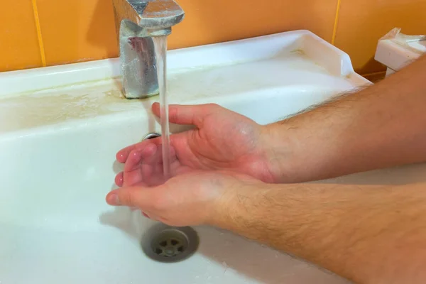 Uomo si lava le mani con acqua e sapone nella vasca da bagno — Foto Stock