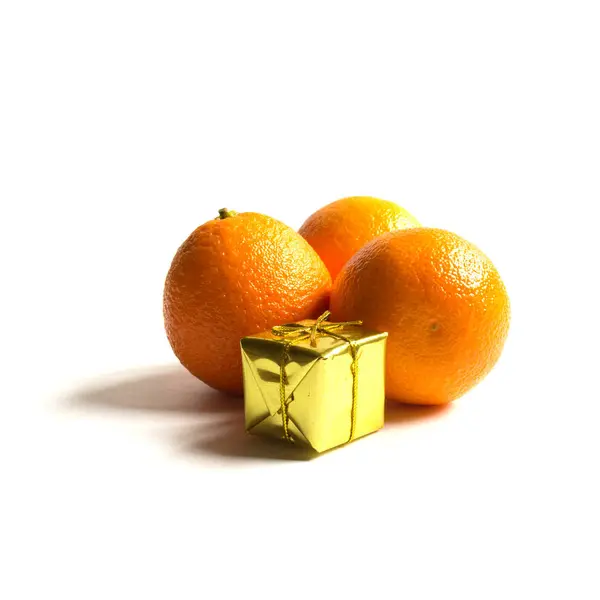 Mandarina y un regalo para el nuevo año sobre un fondo blanco, isol —  Fotos de Stock