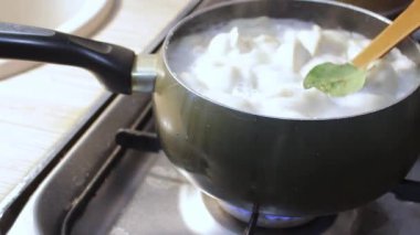 Etli börekler mutfakta kaynar suda pişirilir. Aşçı çorbayı bir yemek makinesiyle karıştırıyor, iştahı açıyor.