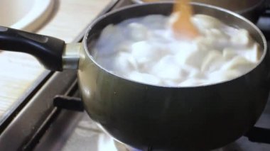 Etli börekler mutfakta kaynar suda pişirilir. Aşçı çorbayı bir yemek makinesiyle karıştırıyor, iştahı açıyor.