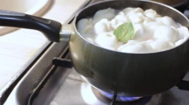 Etli börekler mutfakta kaynar suda pişirilir. Aşçı çorbayı bir yemek makinesiyle karıştırıyor, iştahı açıyor.