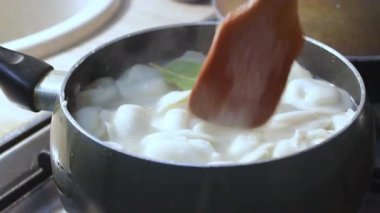 Etli börekler mutfakta kaynar suda pişirilir. Aşçı çorbayı bir yemek makinesiyle karıştırıyor, iştahı açıyor.