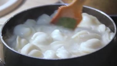 Etli börekler mutfakta kaynar suda pişirilir. Aşçı çorbayı bir yemek makinesiyle karıştırıyor, iştahı açıyor.