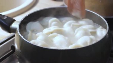 Etli börekler mutfakta kaynar suda pişirilir. Aşçı çorbayı bir yemek makinesiyle karıştırıyor, iştahı açıyor.