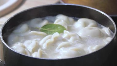 Etli börekler mutfakta kaynar suda pişirilir. Aşçı çorbayı bir yemek makinesiyle karıştırıyor, iştahı açıyor.