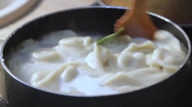 Etli börekler mutfakta kaynar suda pişirilir. Aşçı çorbayı bir yemek makinesiyle karıştırıyor, iştahı açıyor.